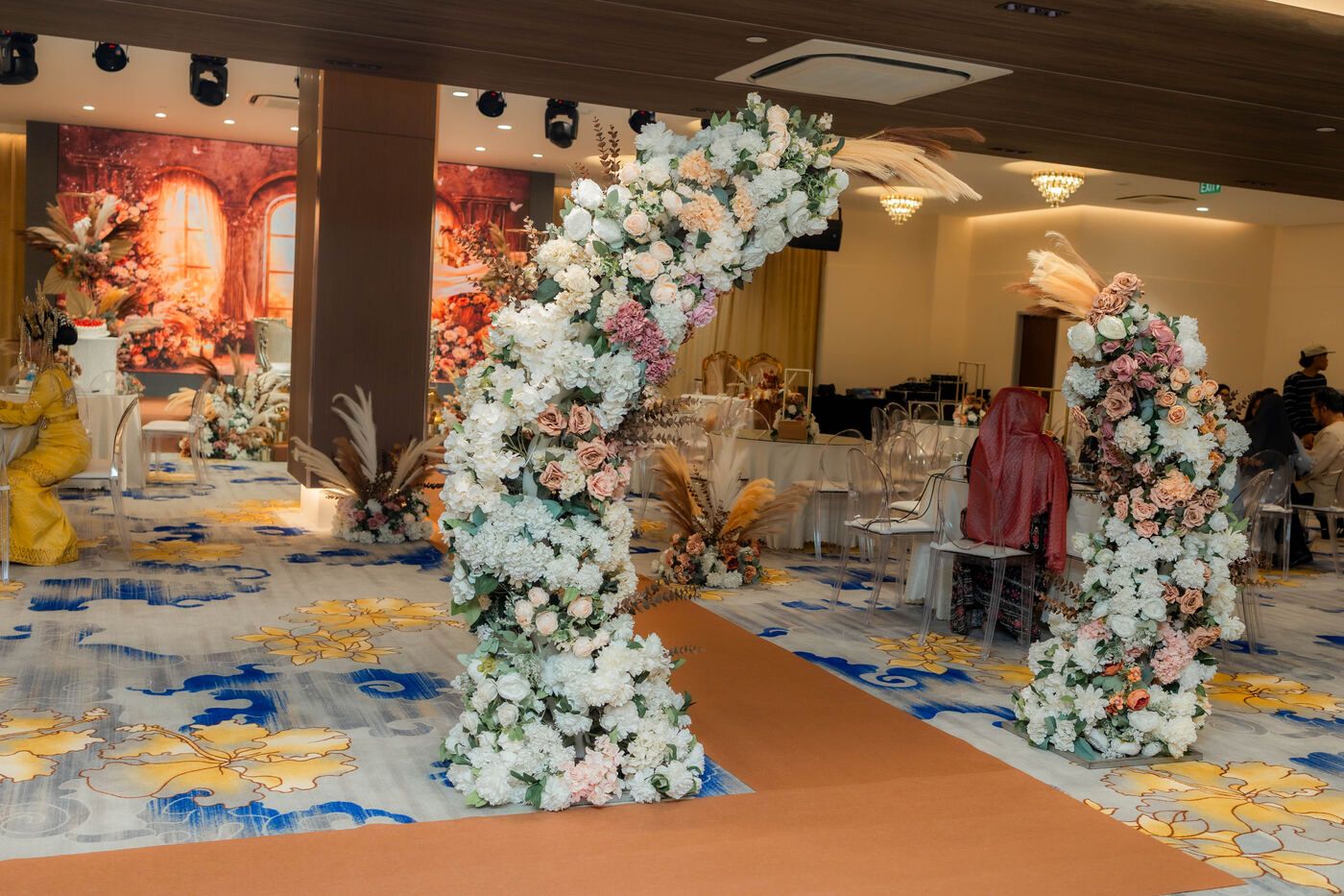 A floral arch over the aisle leading to the wedding stage